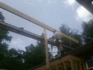 Carpenter setting a ridge beam over a new addition frame — Ice Dam Removal by Roofing Brothers in Hot Sulphur Springs