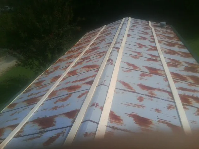 Rusted metal roof panels with new wood purlins before replacement — Storm Damage Roof Repair in Hot Sulphur Springs by Roofing Brothers