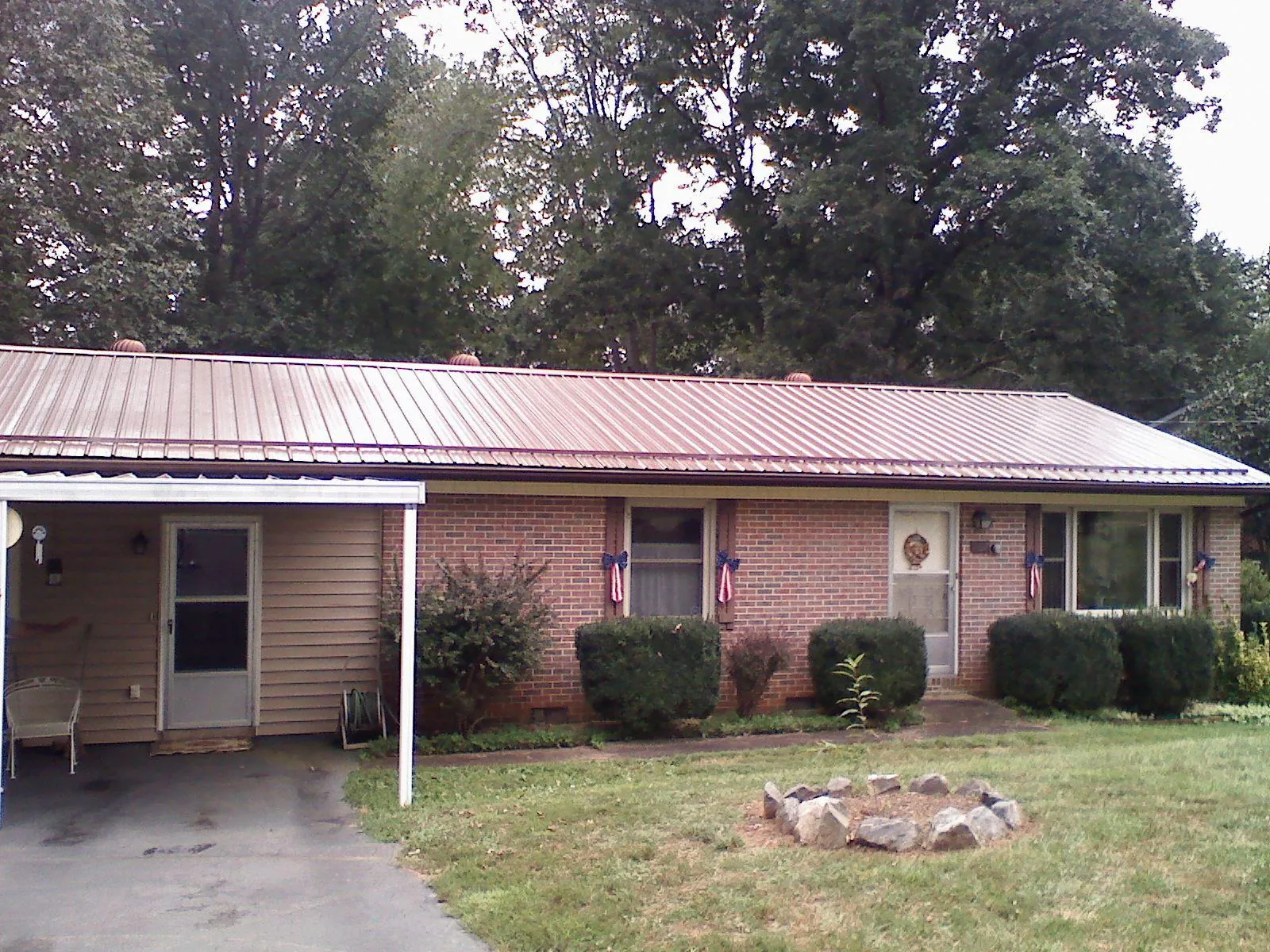Bronze metal roof and carport on a brick ranch home — Roof Repair work by our crew in Hot Sulphur Springs